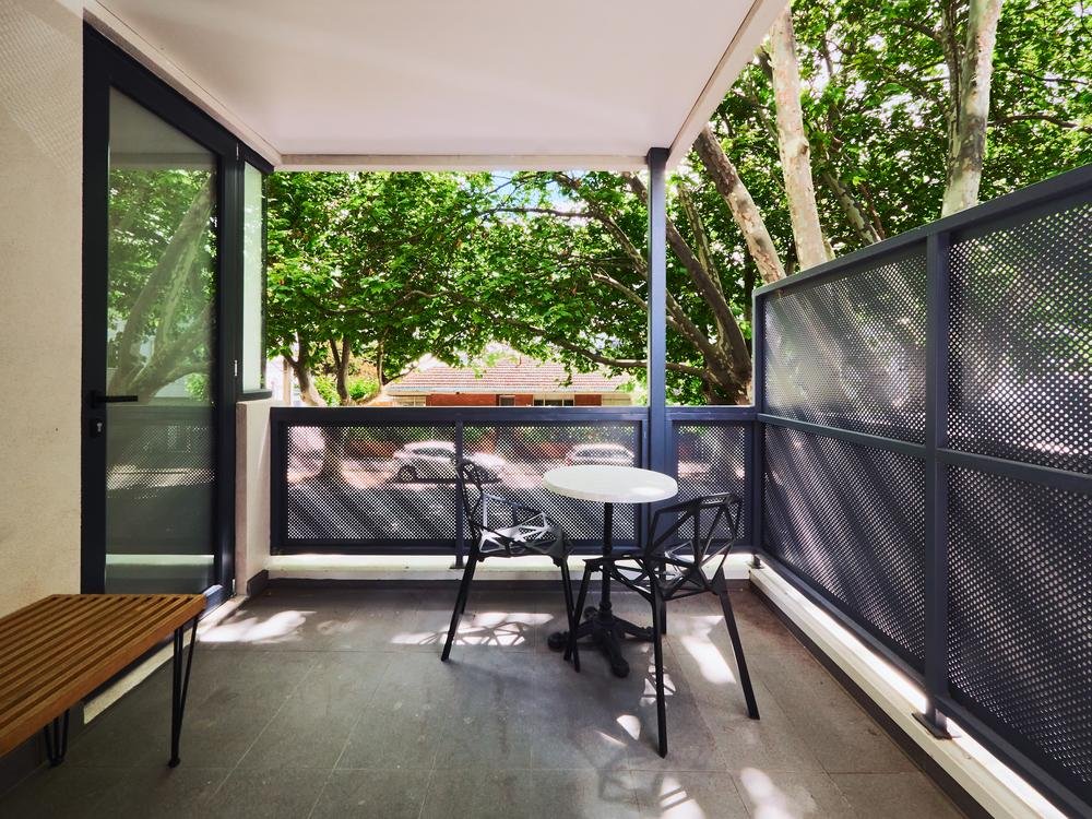 Covered street-level terrace with mature trees